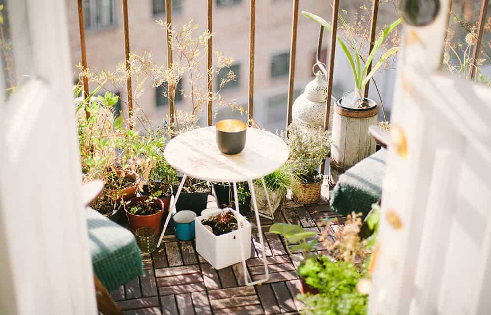 balcon avec plantes en pot et petite table basse